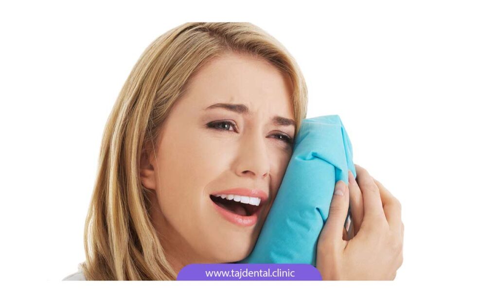 تصویر خانمی در حال نگه داشتن کمپرس سرد بر روی فک خود برای کاهش درد فک