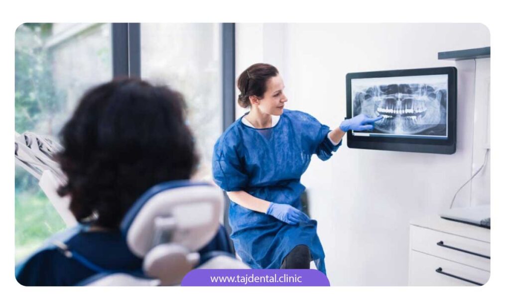 تصویر دندانپزشک در حال نشان دادن عکس opg به بیمار